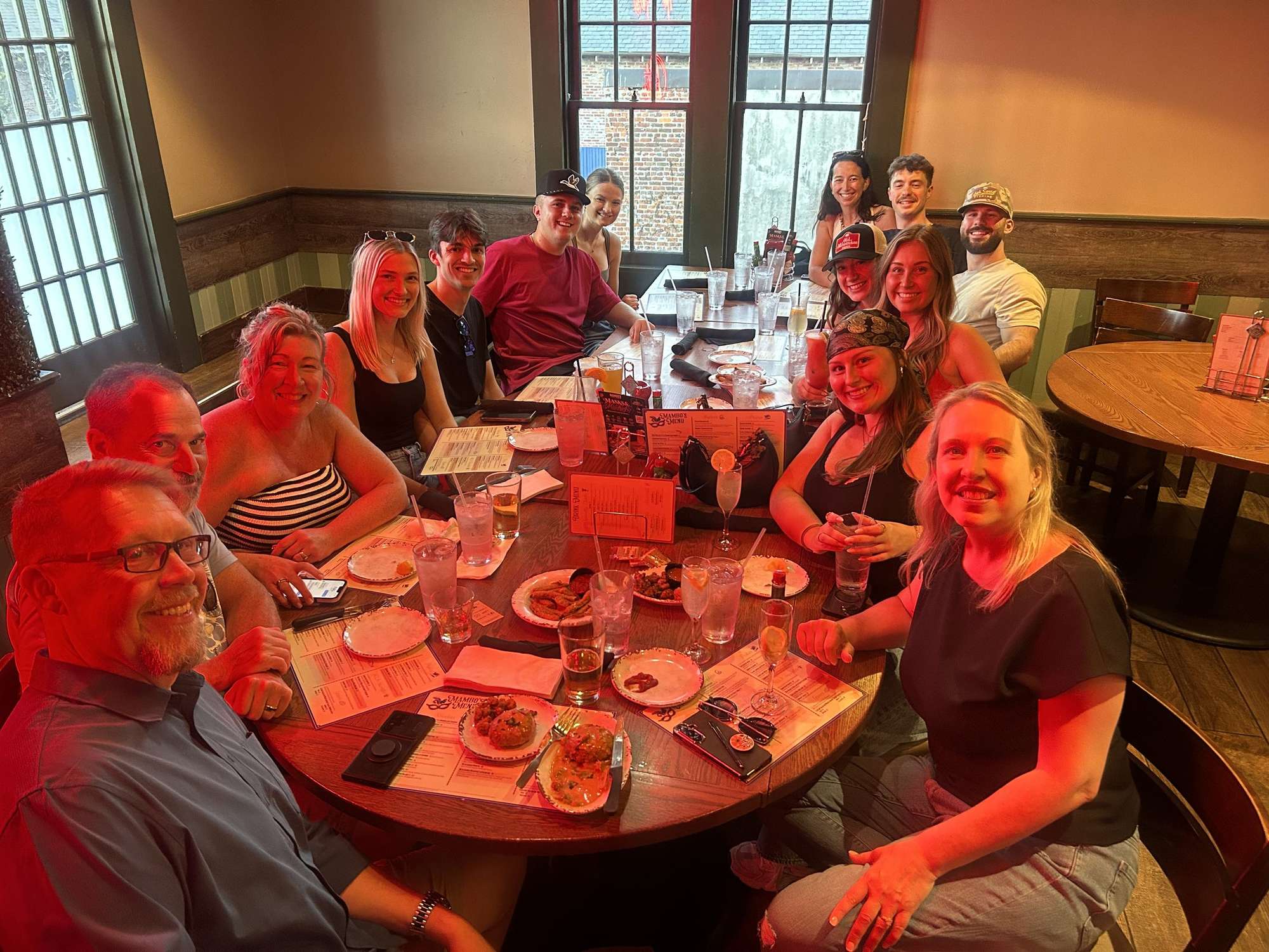 A big group of friends sharing plates around a round table at Mambo's