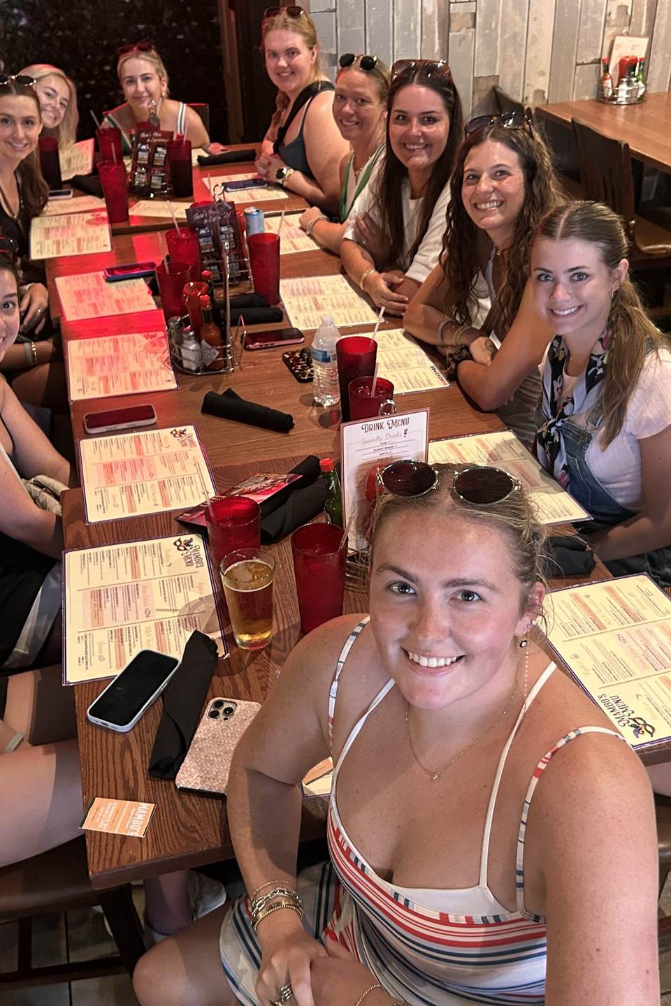 A long table of friends laughing together over lunch in Mambo's dining room