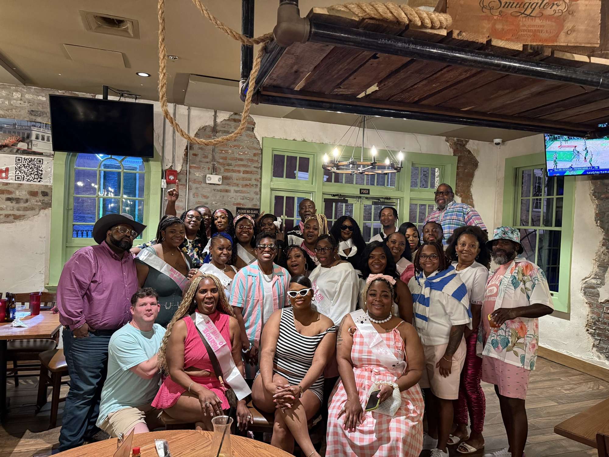 A large celebration group posing together in Mambo's dining room
