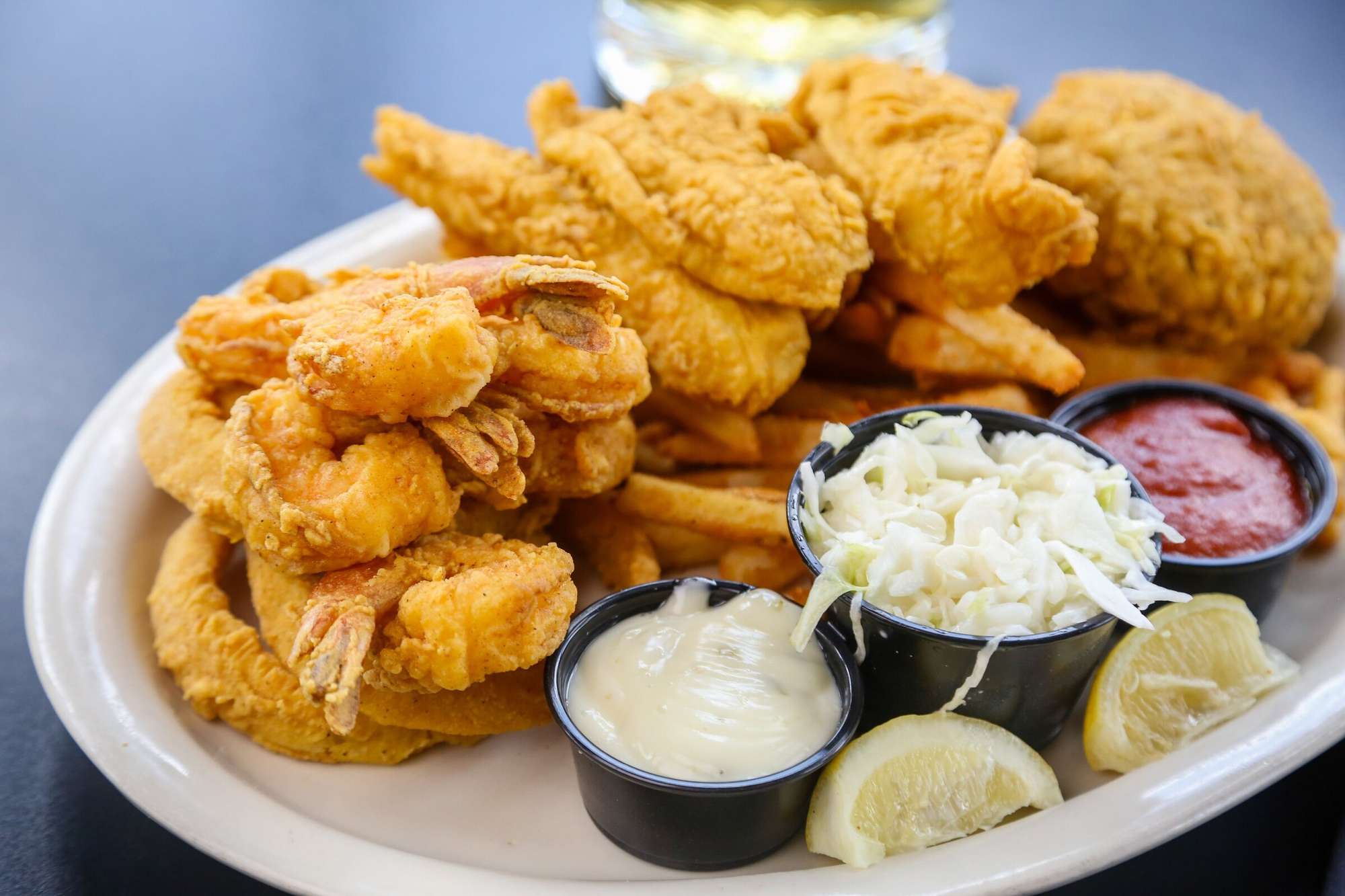 Fried seafood platter with shrimp, oysters and fish, served with fries, hushpuppies and dipping sauces at Mambo's